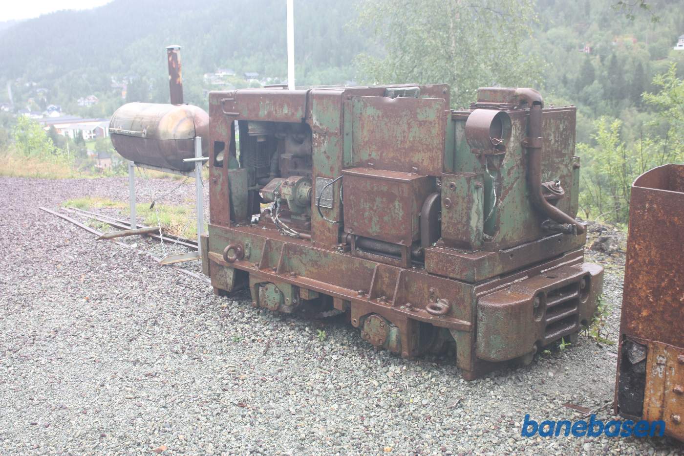 Udenfor minen står de rustne rester af motorlokomotiverne der blev anvendt inde i minen