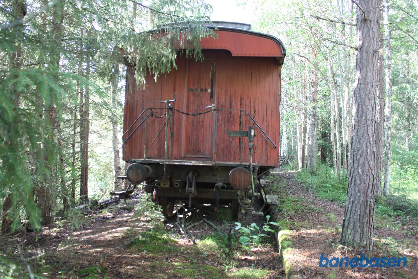 Vi kigger på endegavlen af postvognen. Perronen er fortsat tilbage til højre for vognen