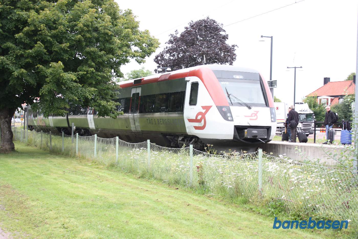 Et ordinært persontog holder ved trinbrættet