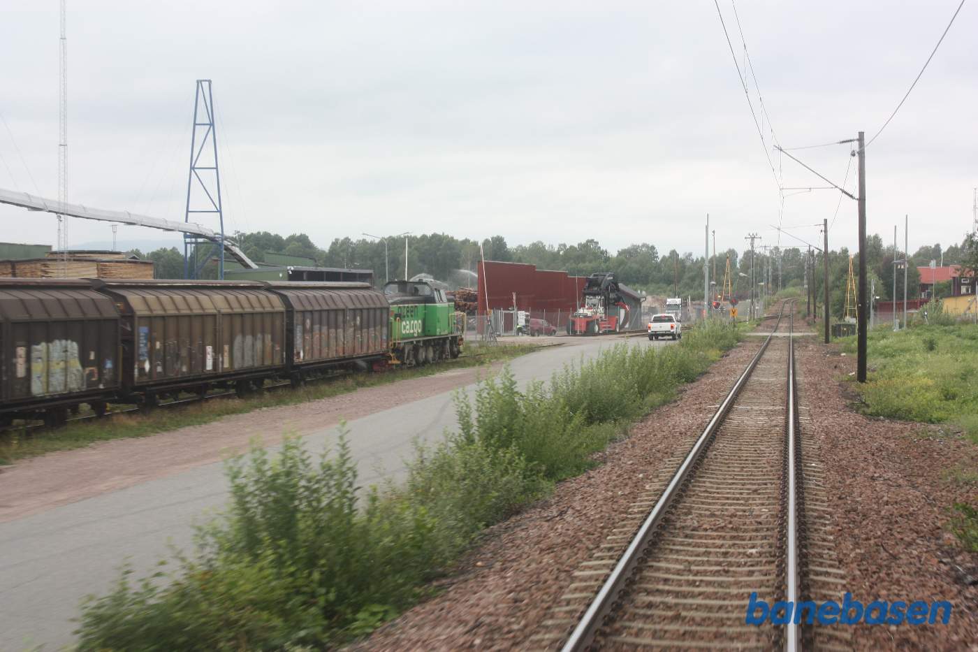 Et bagskud mens toget triller forbi tømmerpladsen lige efter Mora station