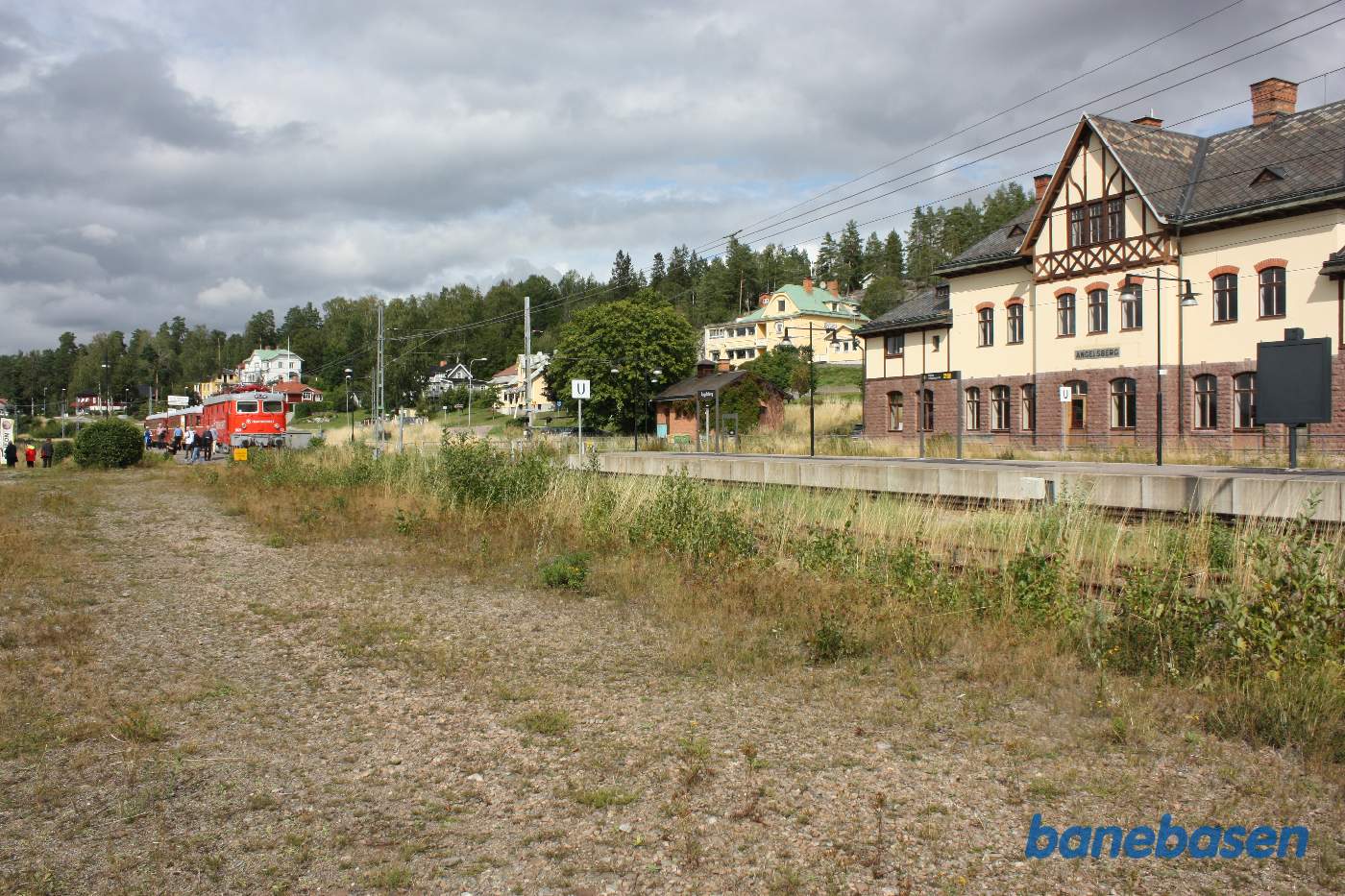 Stationsbygningen set fra læssevejen, udflugtstoget kørt i sidesporet og gæsterne på vej ud af toget