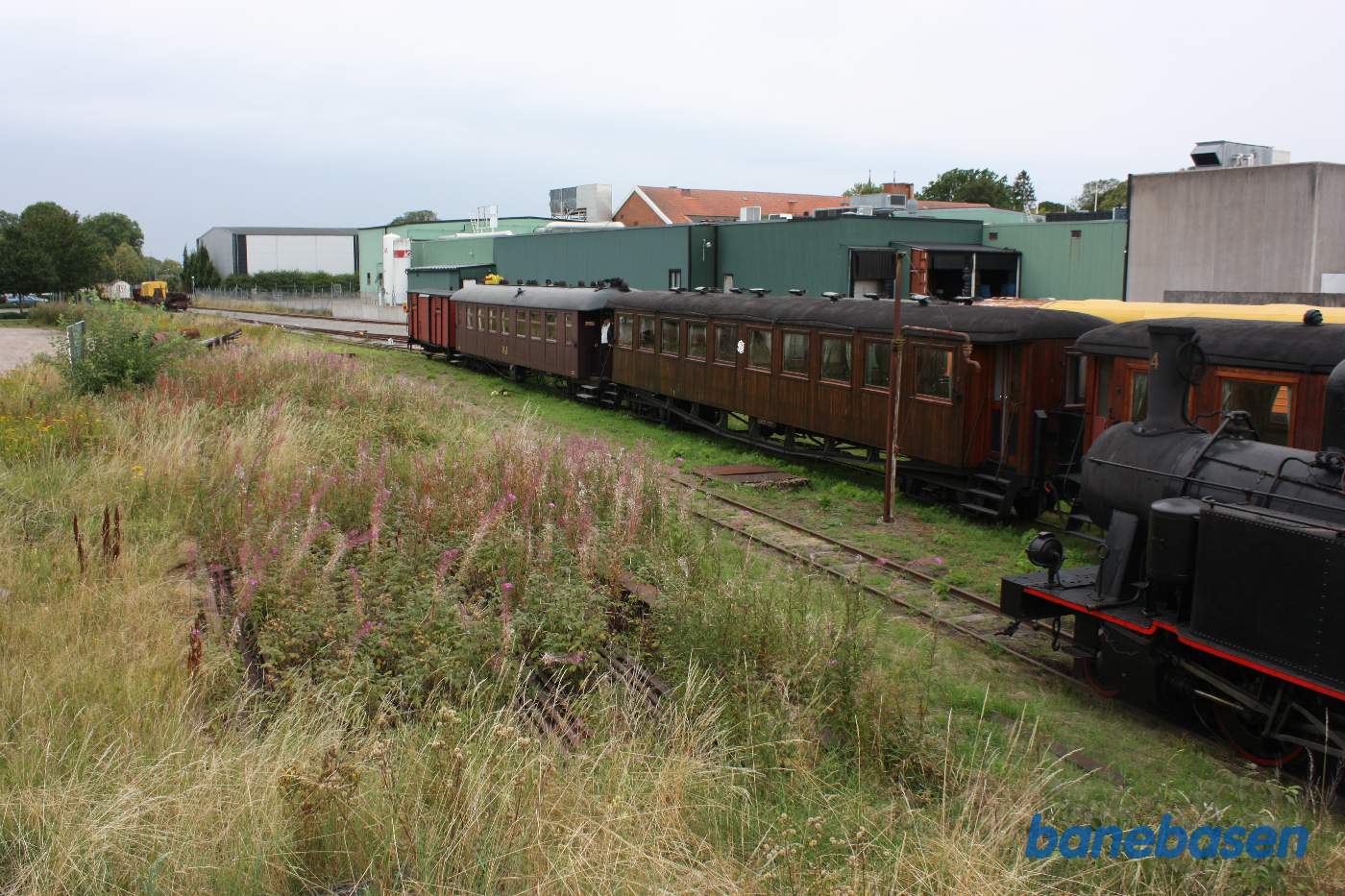 Vognene til dagens tog holder klar bag damplokomotivet
