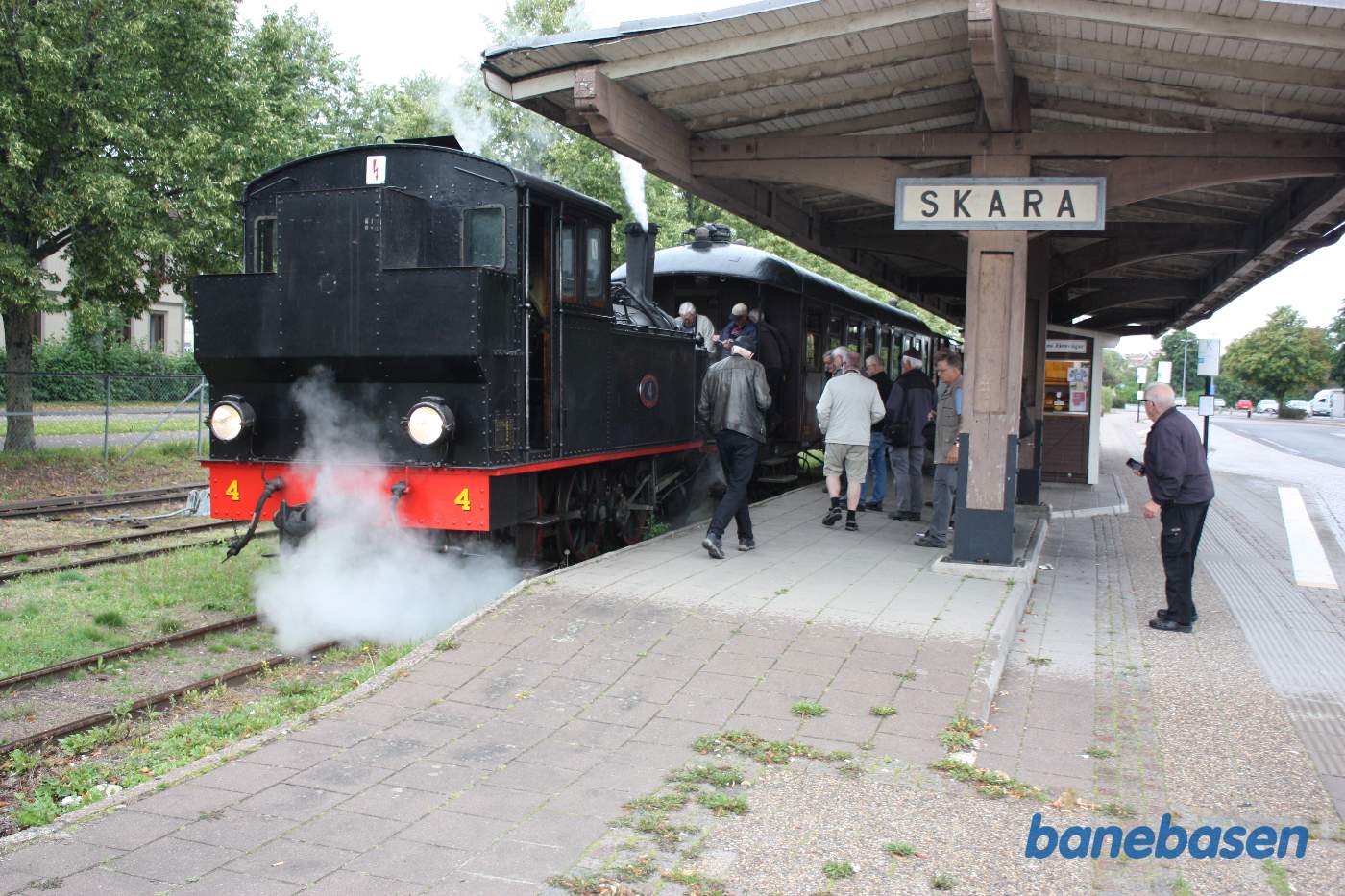 Damplokomotivet kobles til vognene mens gæsterne ser på