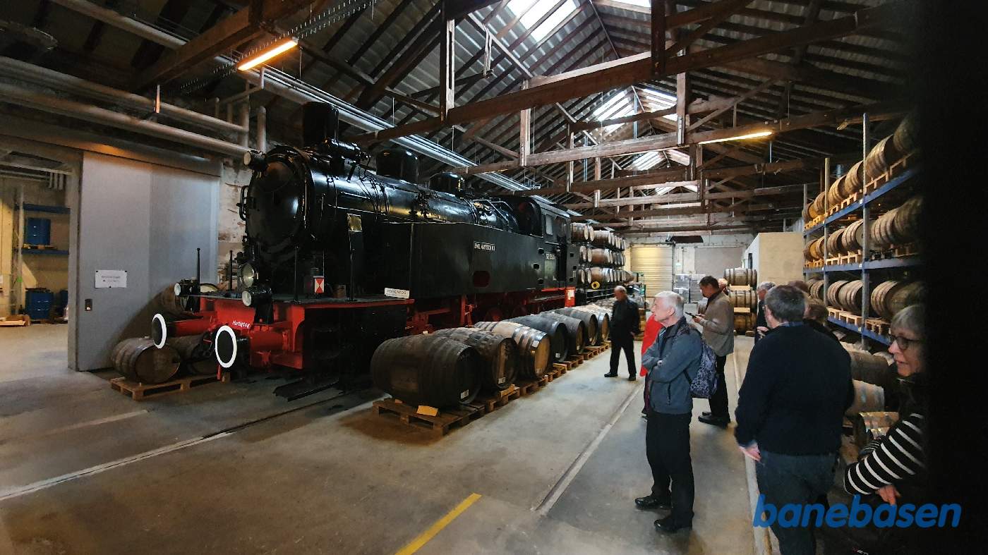 Inde i lagerhallen, med de mange trætønder, står et tysk damplokomotiv