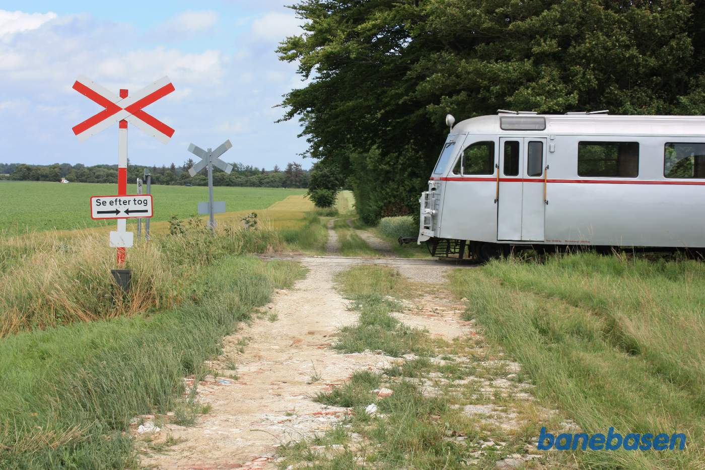Skinnebussen er stoppet ved en privat overkørsel til en gård inde bag træerne til højre
