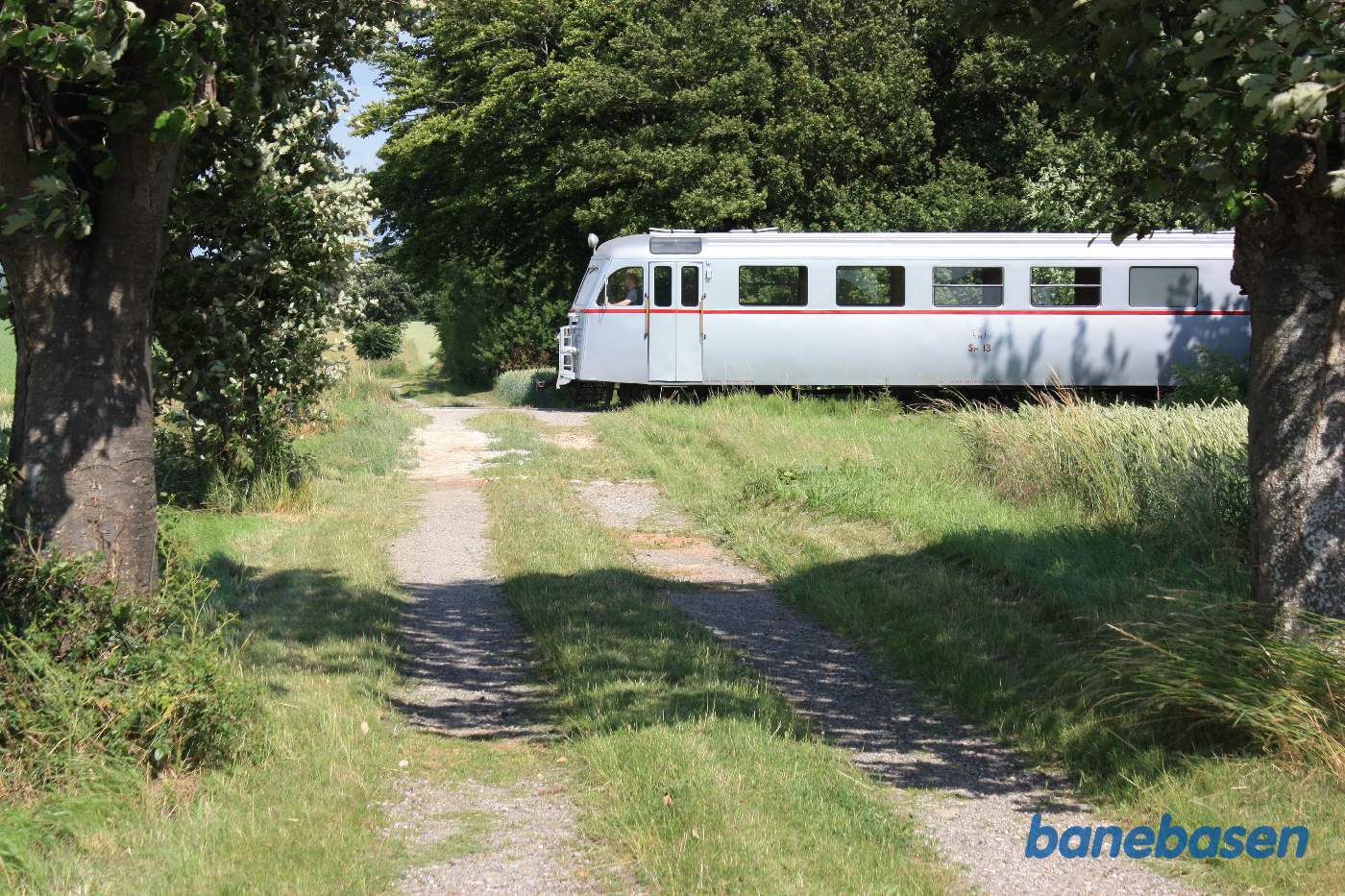 Skinnebussen er stoppet ved en privat overkørsel til en gård inde bag træerne til højre