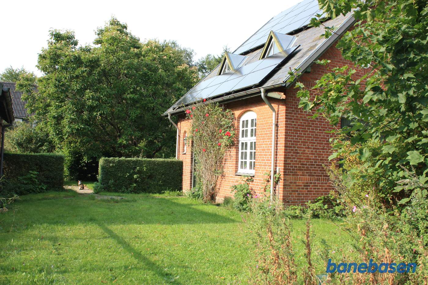 Stationsbygningen set fra perronen, langs sidevæggen, pakhuset ses til venstre i billedet (tagrenden)