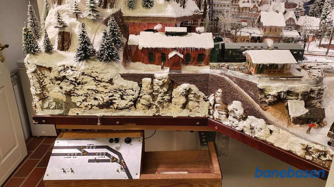 Et vue ud over hele hjørnet med snelandskabet, stationens sikringsanlægs betjeningspanel ses nede i billedet Et vue ud over hele hjørnet med snelandskabet, stationens sikringsanlægs betjeningspanel ses nede i billedet