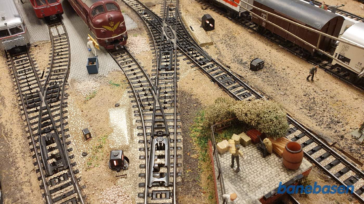 Nærbillede af et modificeret standard sporskifte, hvor fotografen har skåret en stor bid af det lige spor, for at få plads til skiftet på den snævre plads Nærbillede af et modificeret standard sporskifte, hvor fotografen har skåret en stor bid af det lige spor, for at få plads til skiftet på den snævre plads