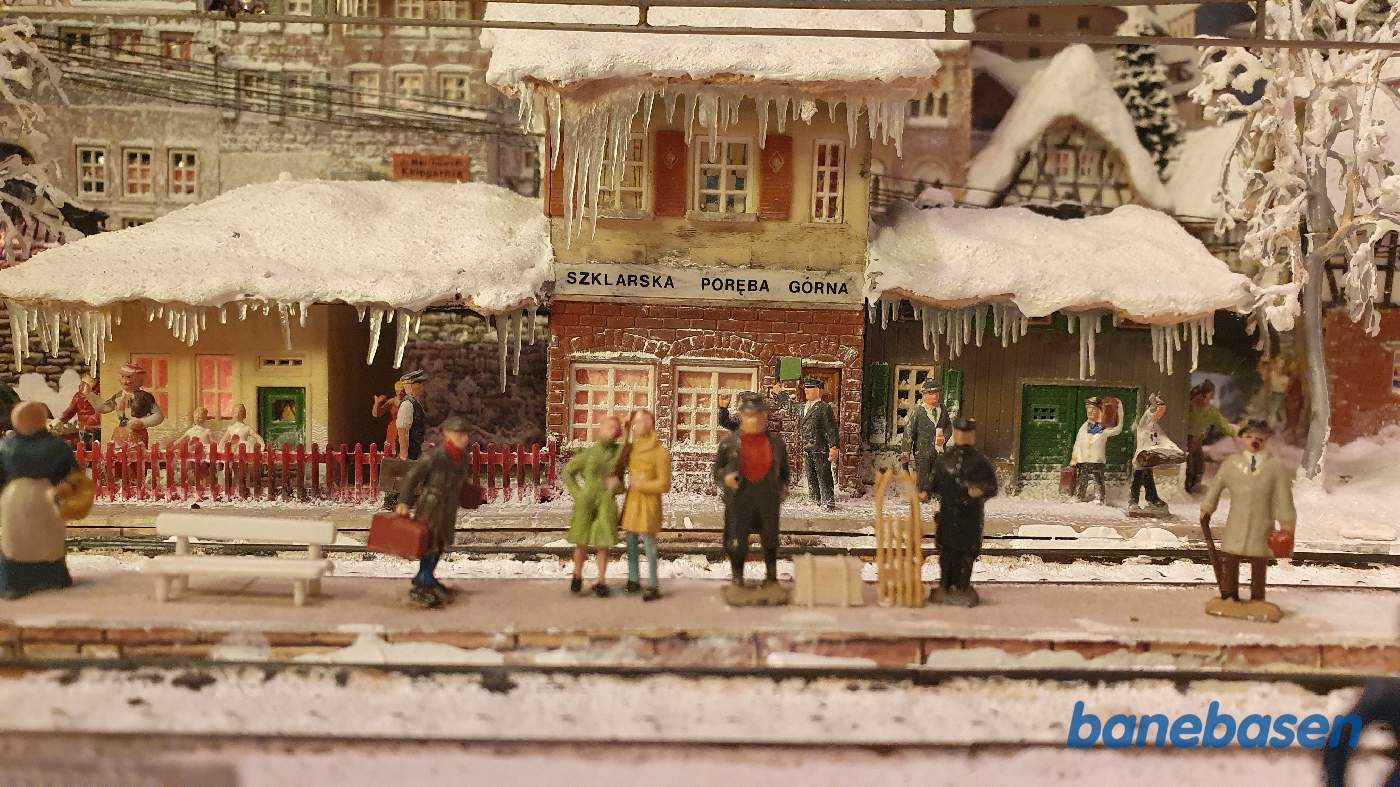 Stationsbygningen set fra banen med rejsende på perronen Stationsbygningen set fra banen med rejsende på perronen