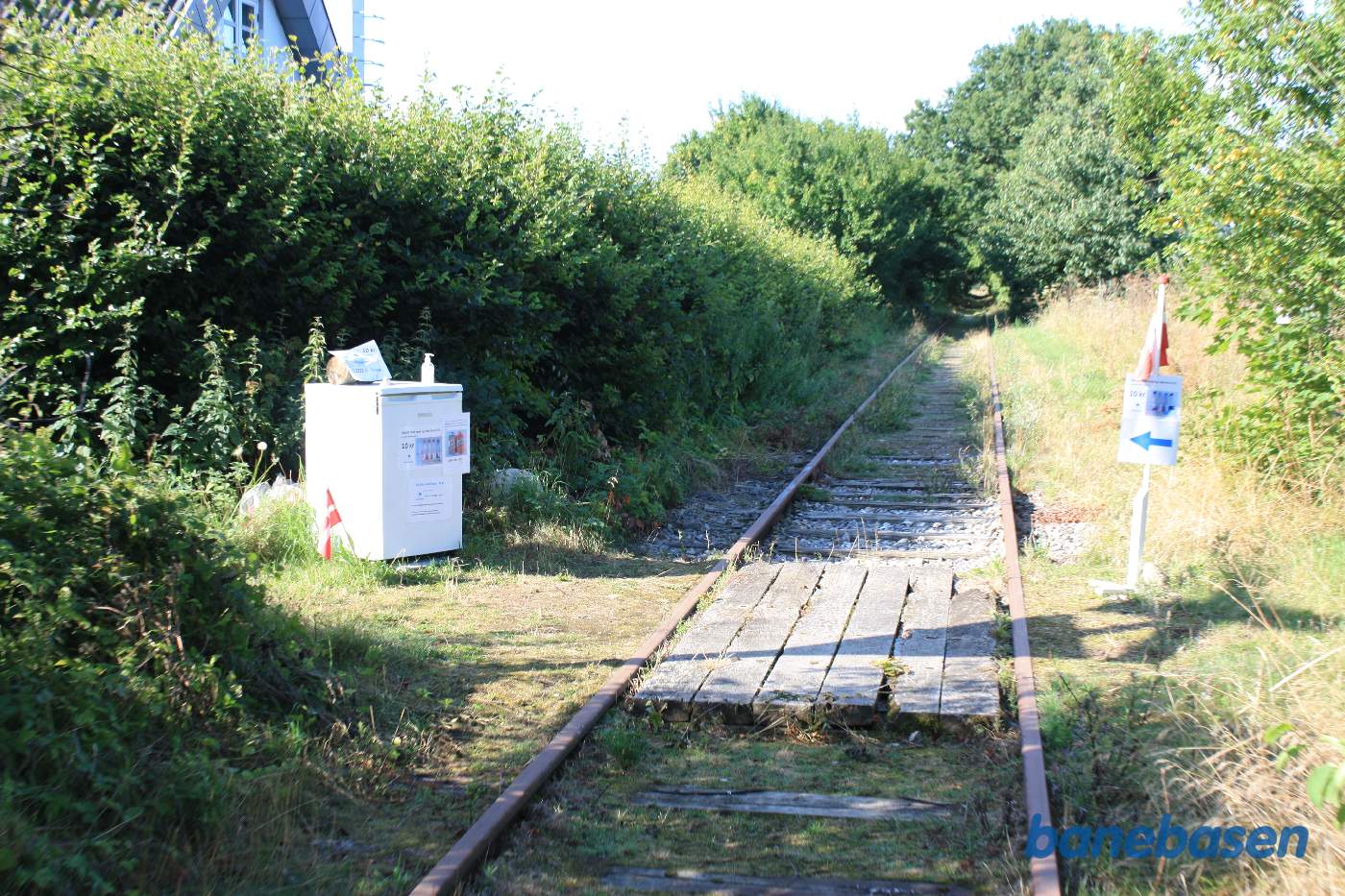 Ved det nedlagte trinbræt, har husejeren til venstre stillet et køleskab op med kolde drikke - herligt i den stærke sommervarme