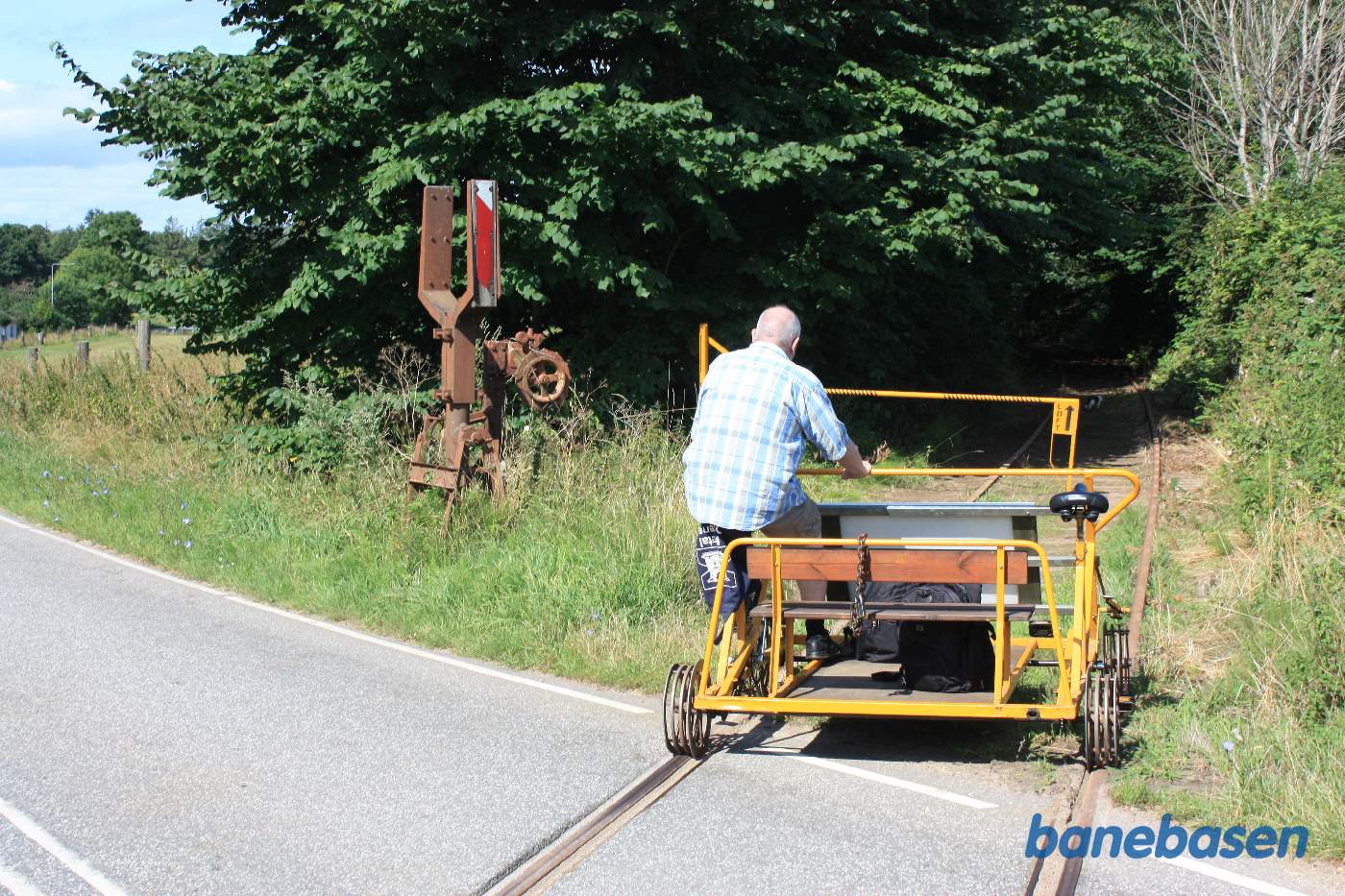 Skinnecyklen passerer vejen og fortsætter ind mellem træerne Skinnecyklen passerer vejen og fortsætter ind mellem træerne