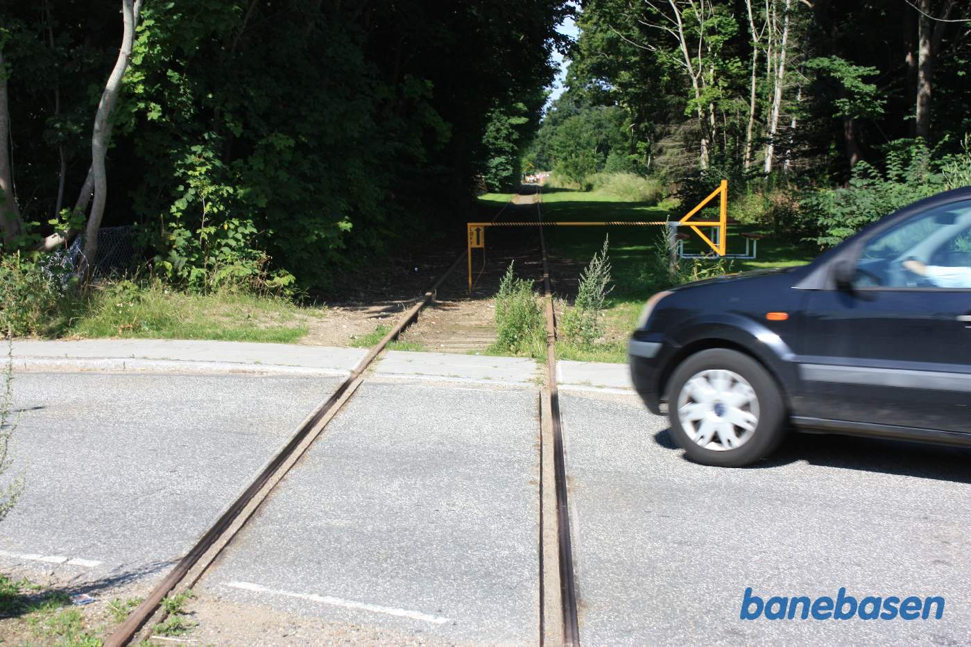 Lige før Ebberup station, krydser vi over Ravnekærvej, stationen ligger inde bag træerne til venstre