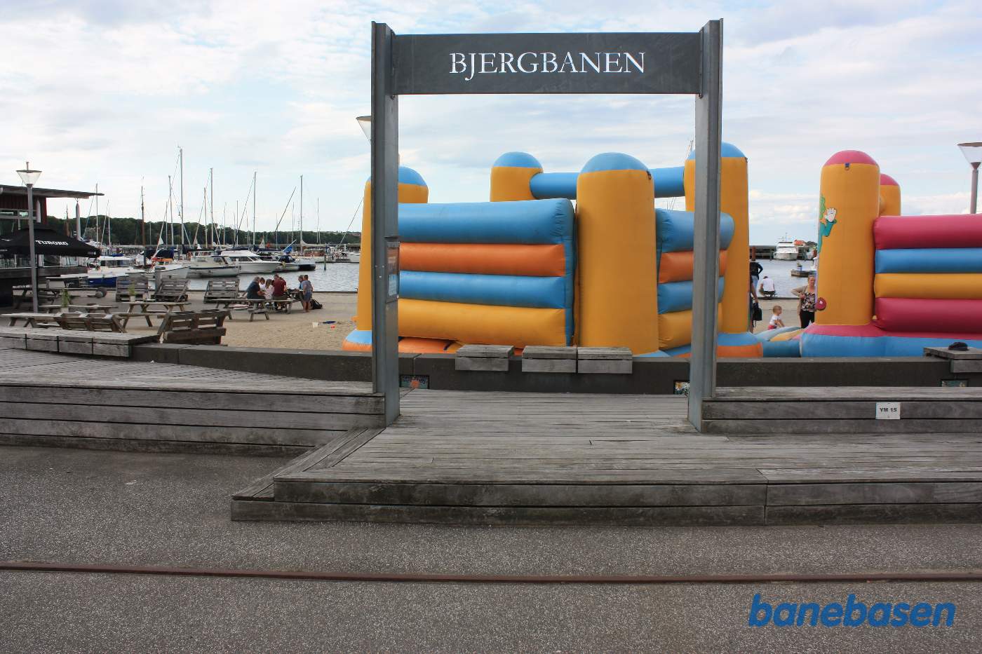 Stationsskiltet med teksten "Bjergbanen" med havnen i baggrunden