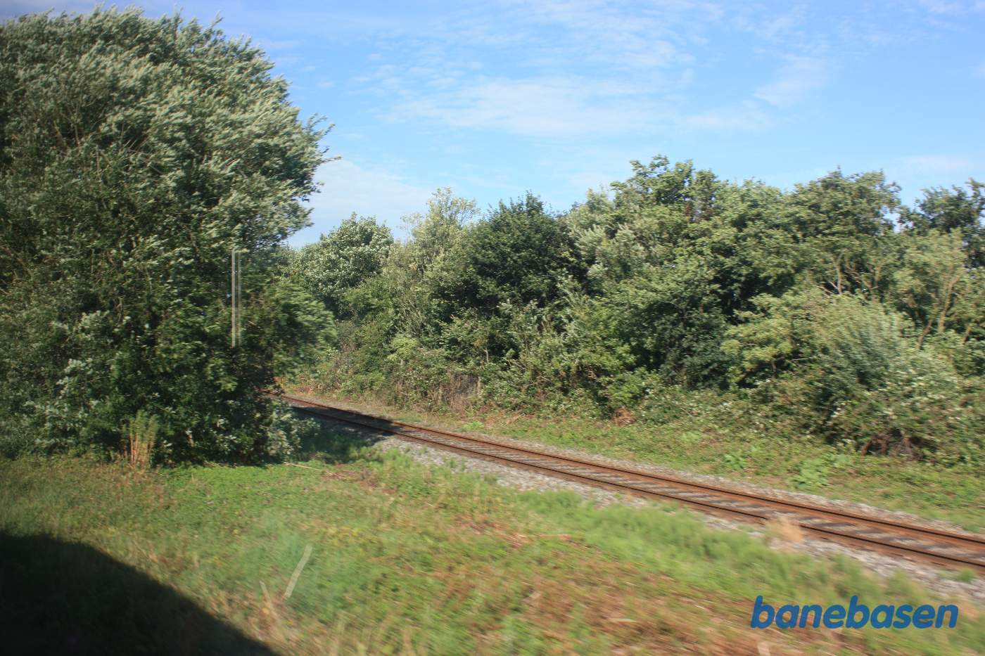 Vi er på vej ud af Lemvig station i retning mod Vemb og ser sporet til Thyborøn ud af togvinduet Vi er på vej ud af Lemvig station i retning mod Vemb og ser sporet til Thyborøn ud af togvinduet