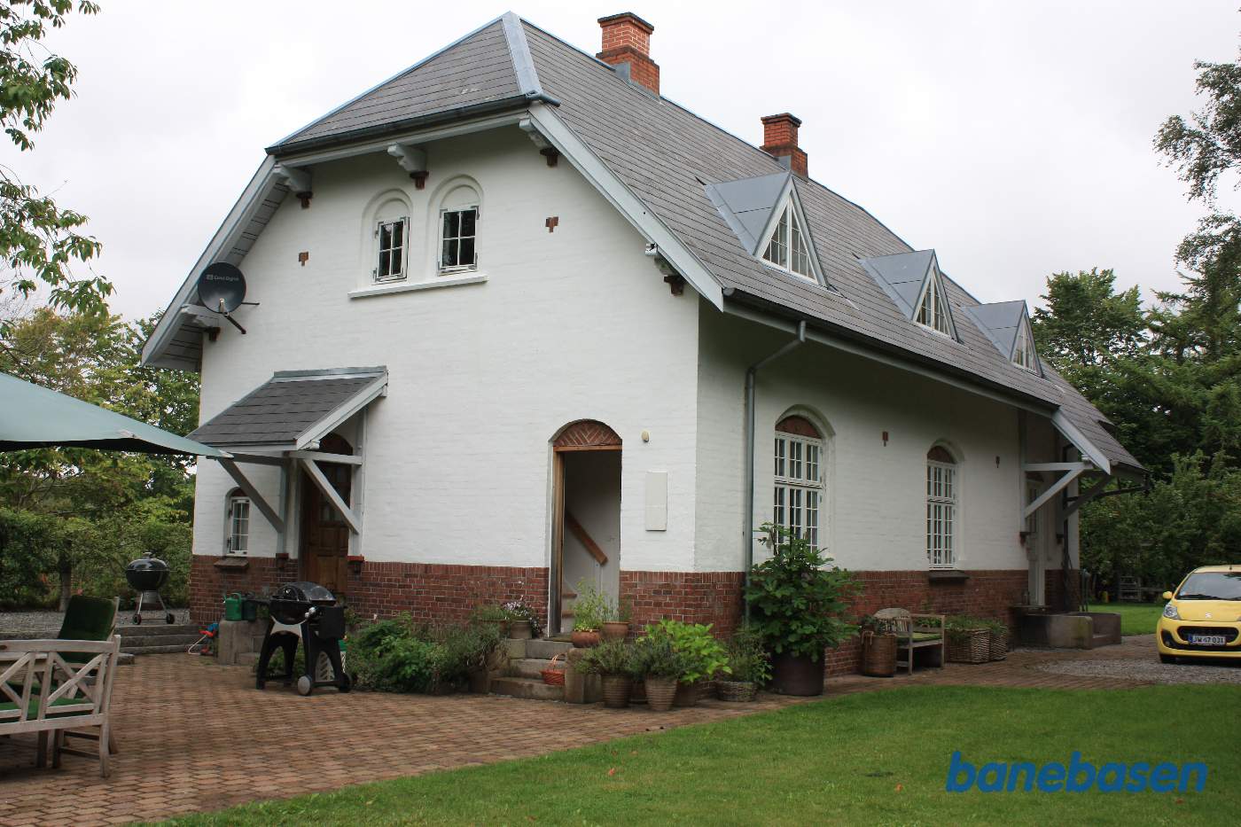 Stationsbygningen set fra vejen, der nu er have