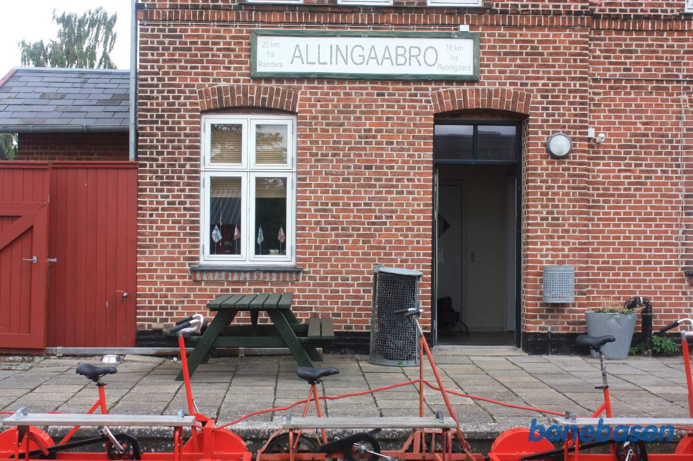 Indgangen til stationsbygningen med stationsskiltet, 20 km fra Randers og 16 km fra Ryomgaard