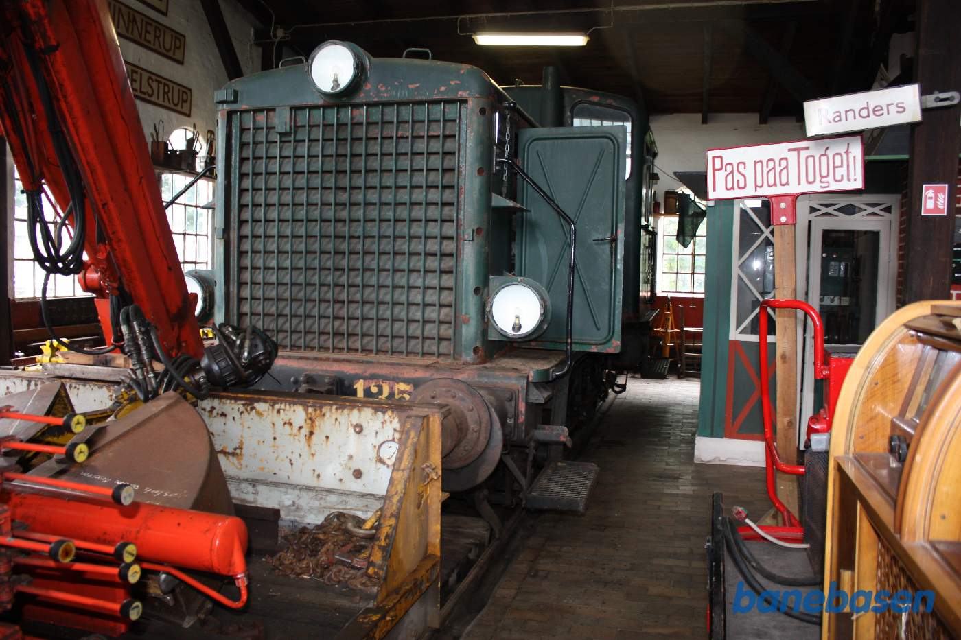 Inde i remisen et grønt rangerlokomotiv Inde i remisen et grønt rangerlokomotiv