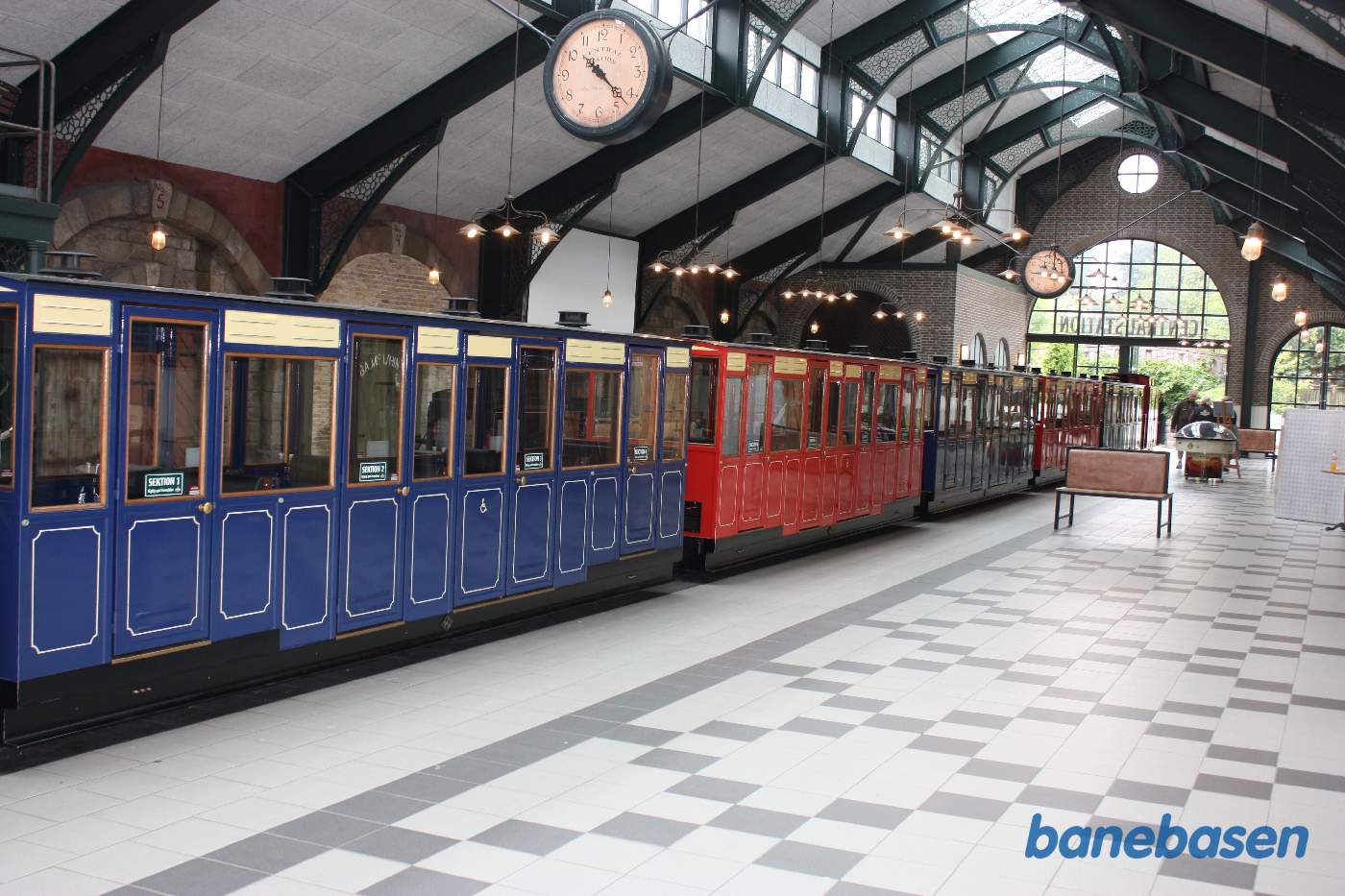 Det lange persontog holder nu inde i hallen, et rigtigt farvelade tog