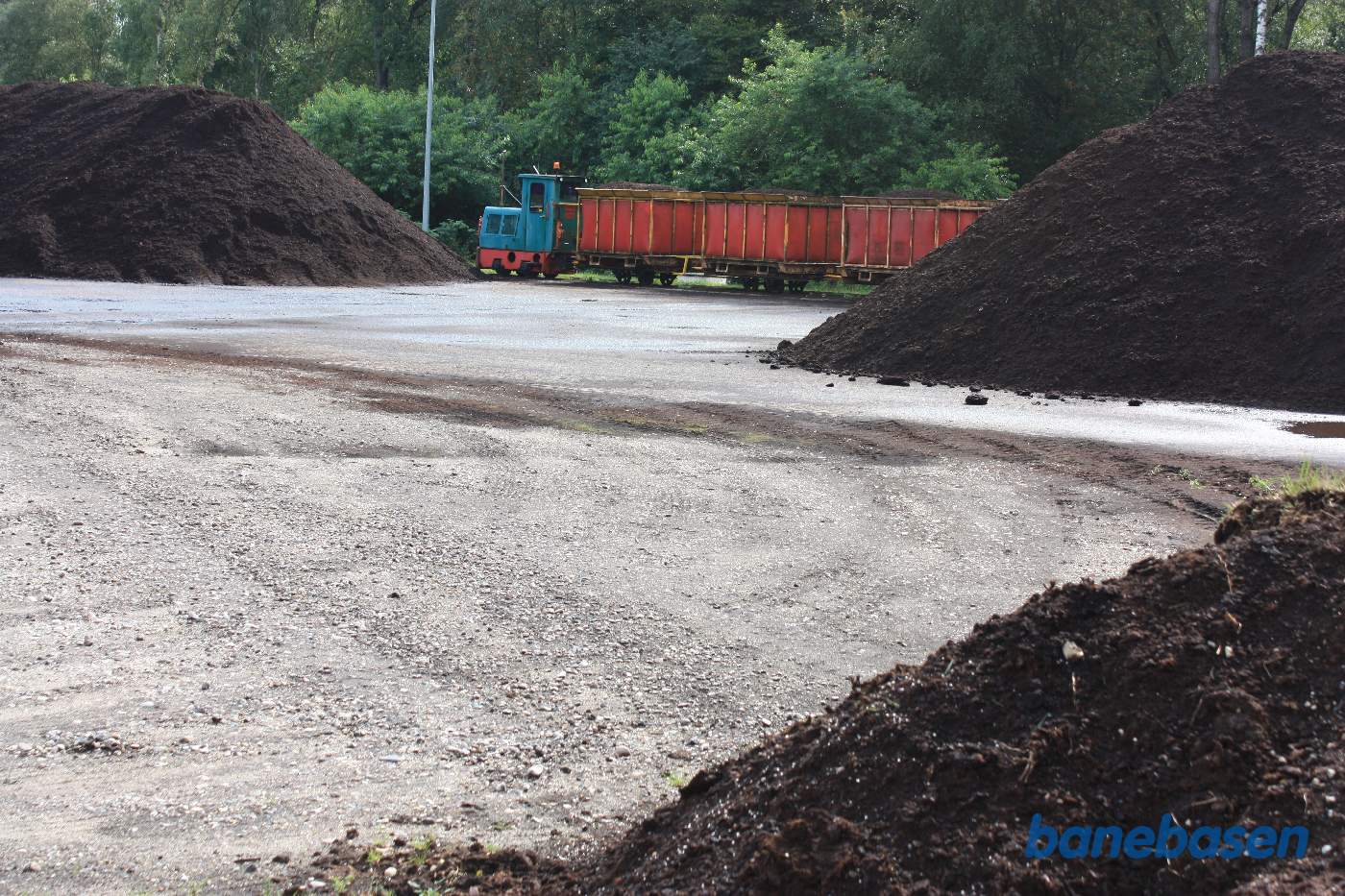 Det lille tog holder på den anden side af de store bunker af mosejord Det lille tog holder på den anden side af de store bunker af mosejord
