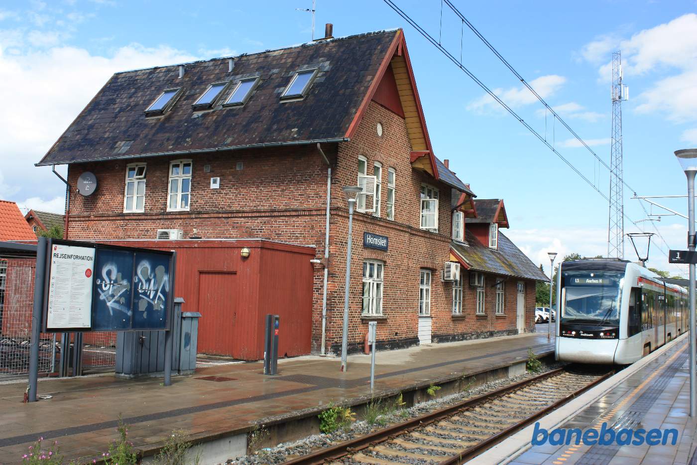 Stationsbygningen set fra perronen med letbanetog mor Aarhus