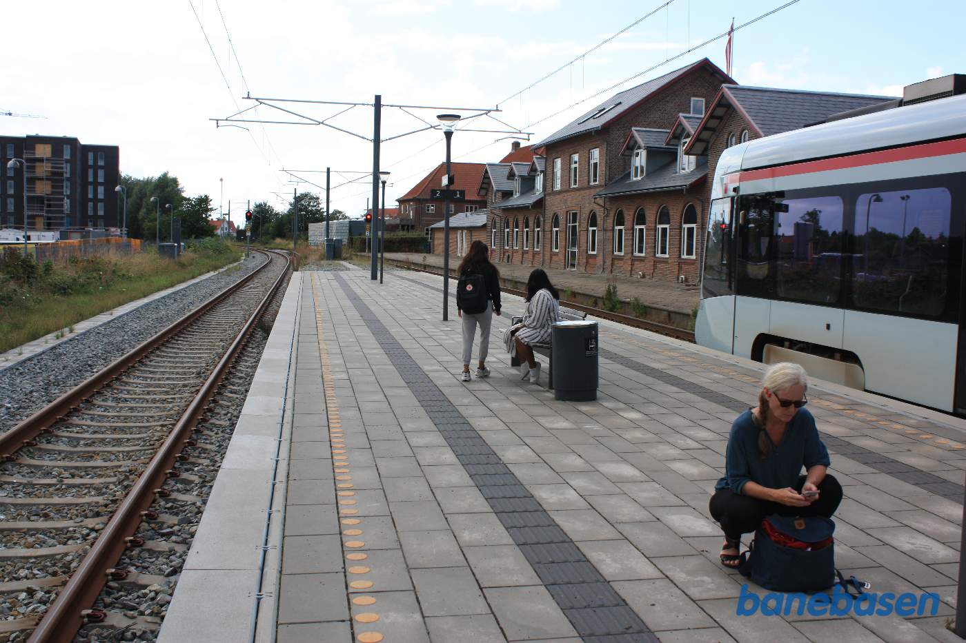 Stationsbygningen ses til højre bag letbanetoget Stationsbygningen ses til højre bag letbanetoget