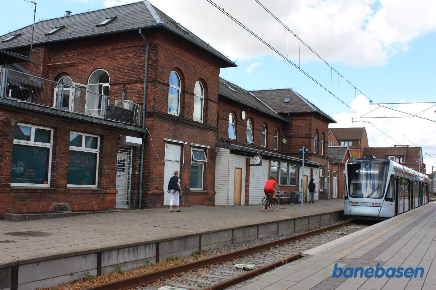 Stationsbygningen med letbanetog ved perron