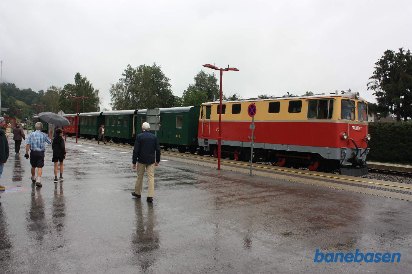 Gæsterne går ud i regnen mens toget holder ved perron