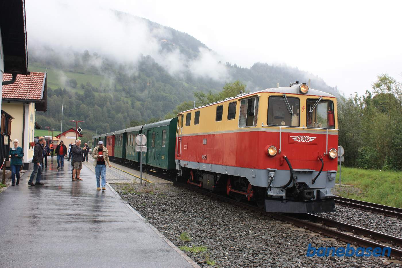 Gæsterne går ud i regnen mens toget holder ved perron