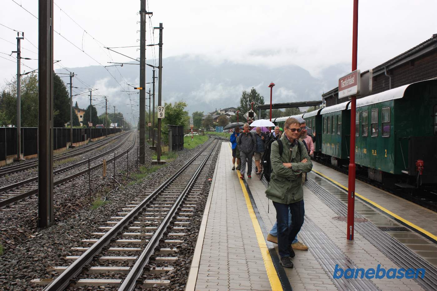 Personvognene efterladt ved perron mens gæsterne står i regnen