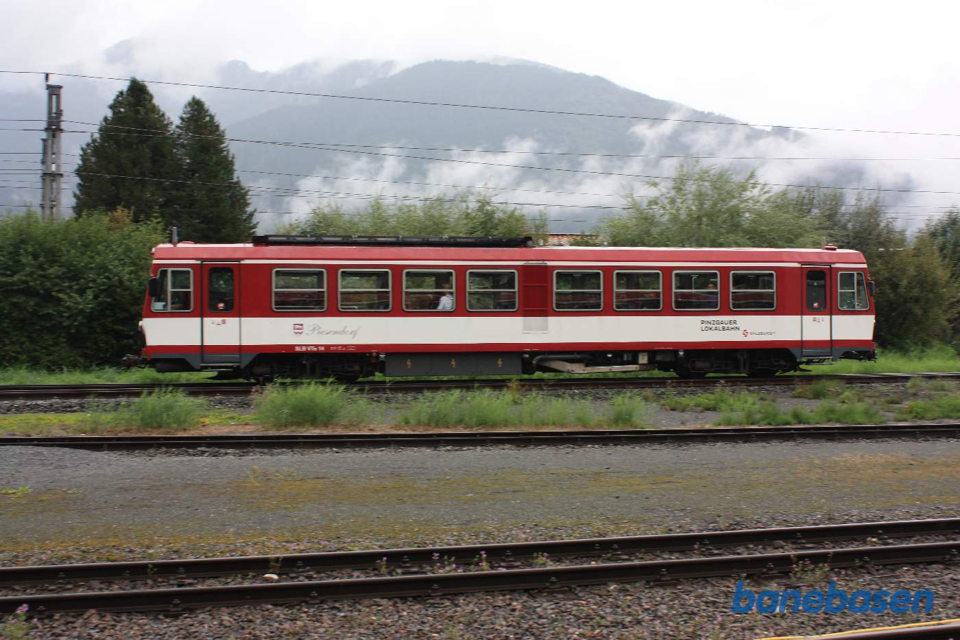 En motorvogn med passagerer suser forbi remiseområdet