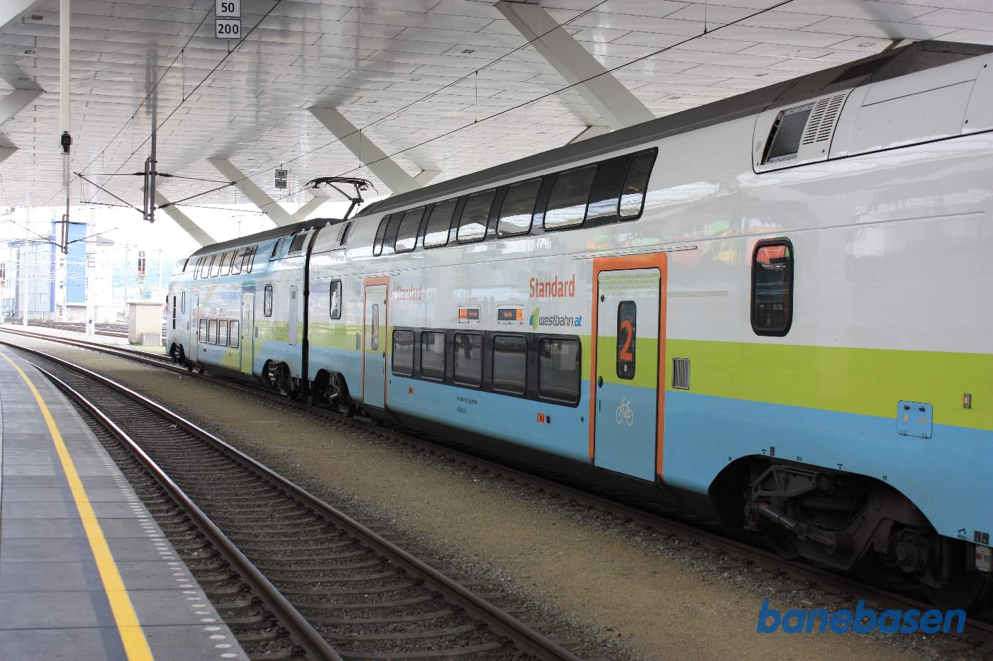 Et dobbeltdækker lokaltog holder ved perron