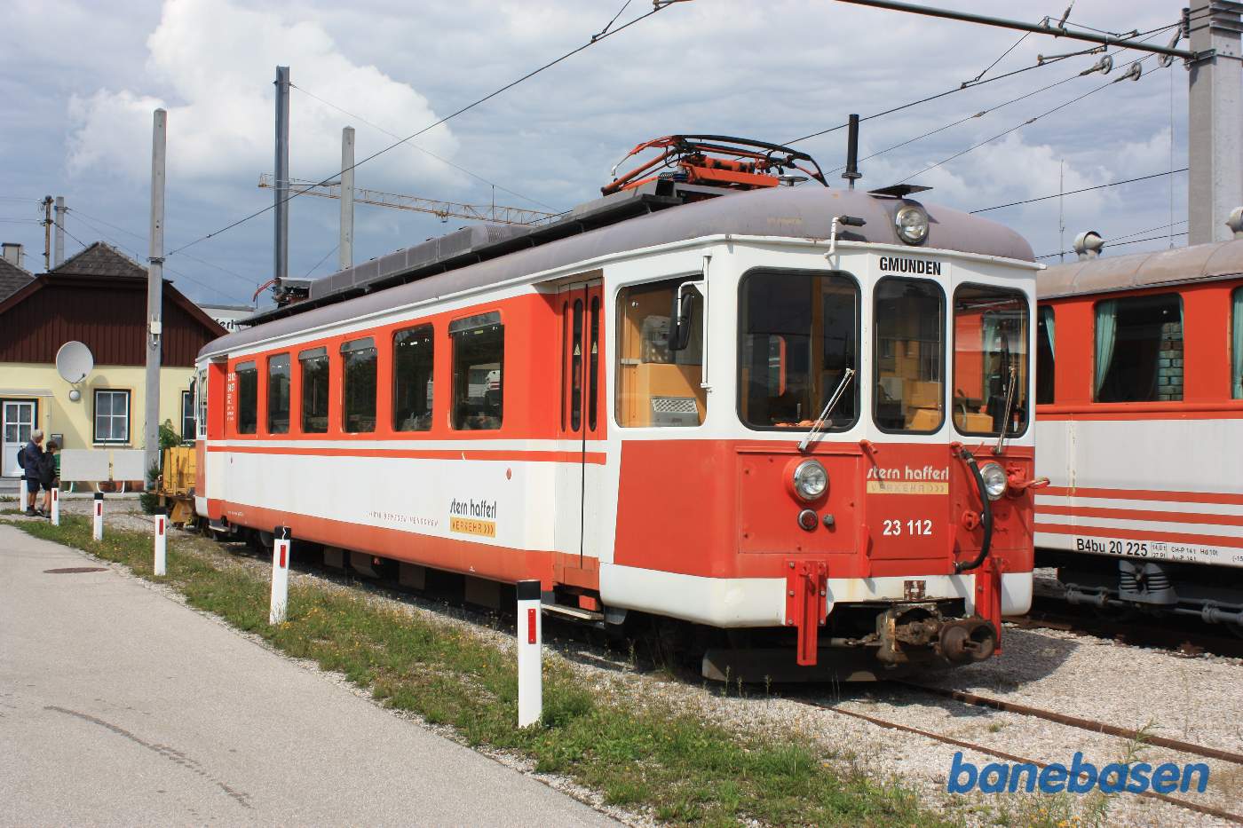 En elektrisk motorvogn i sidesporet, stationsbygningen i baggrunden