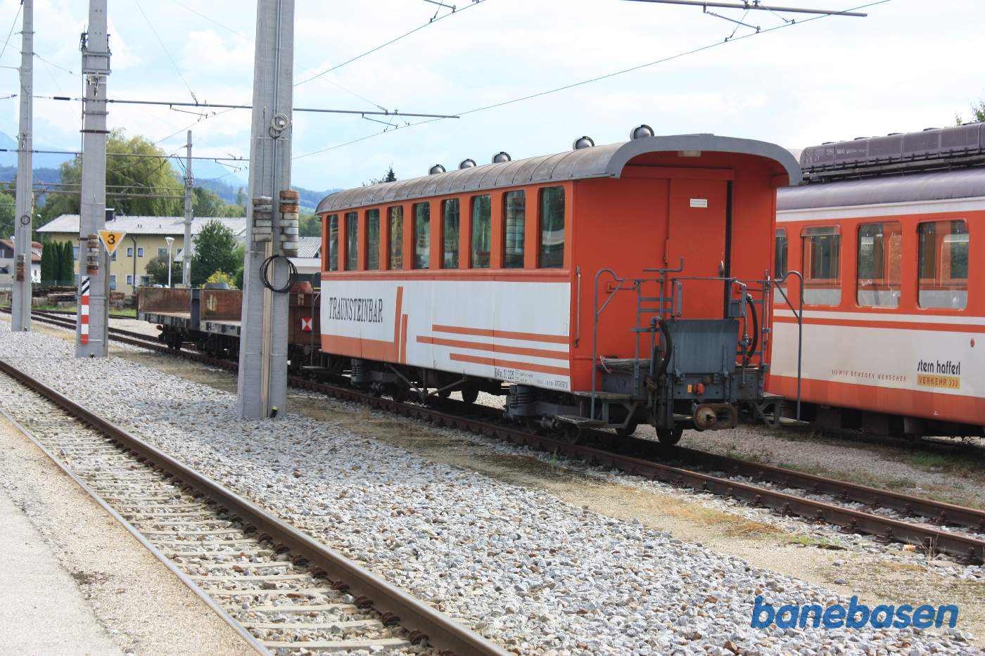 En ældre personvogn med automatkobling på et af sporene foran remisen