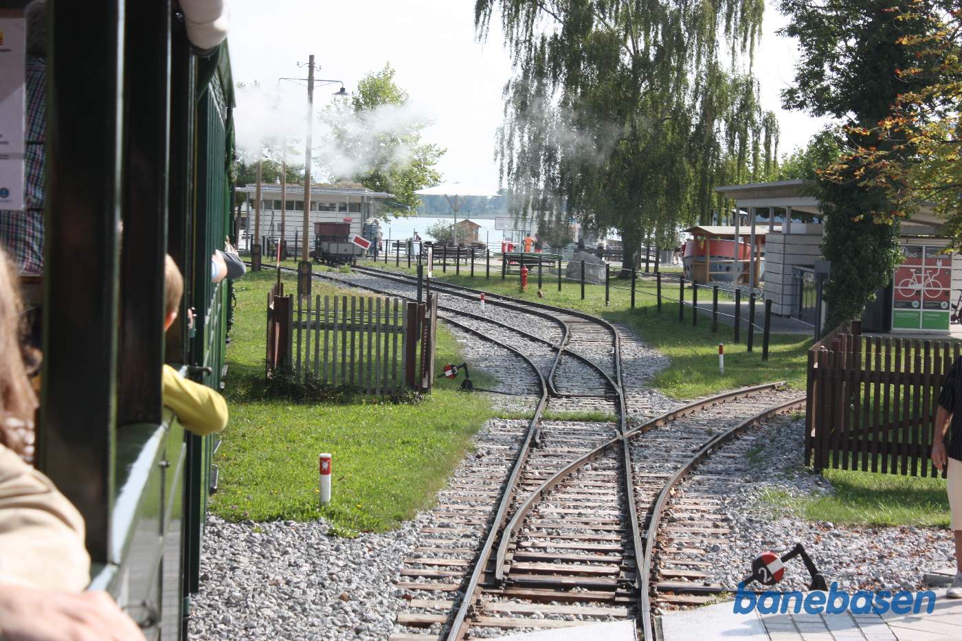 Damptoget på vej ind på stationen, søen ses i baggrunden