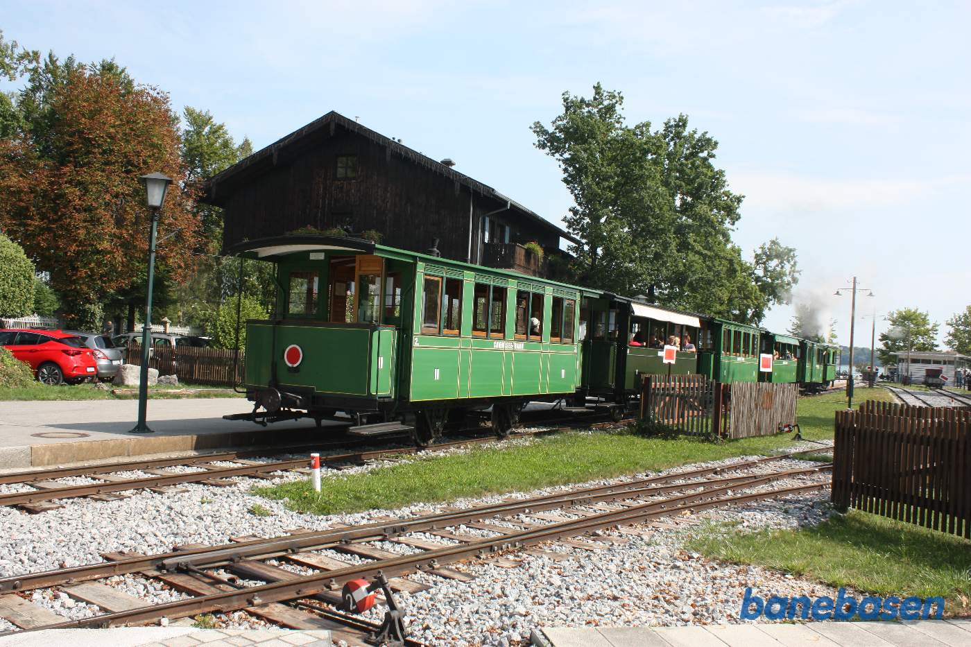 Damptoget på vej ind på stationen, søen ses i baggrunden