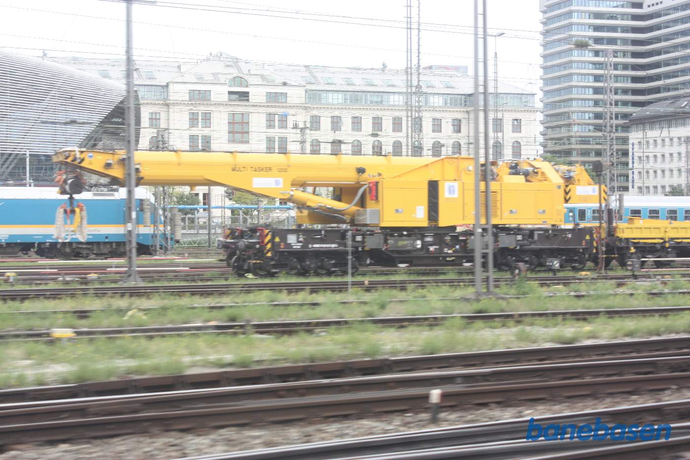 En stor gul jernbanekran er hensat i et spor på stationen