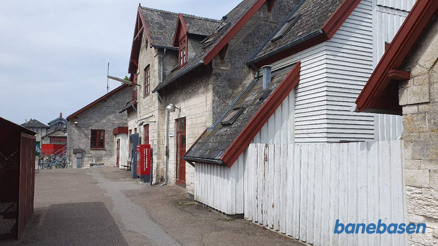 Stationsbygningen inde til højre og remisen længere ude bag den røde container