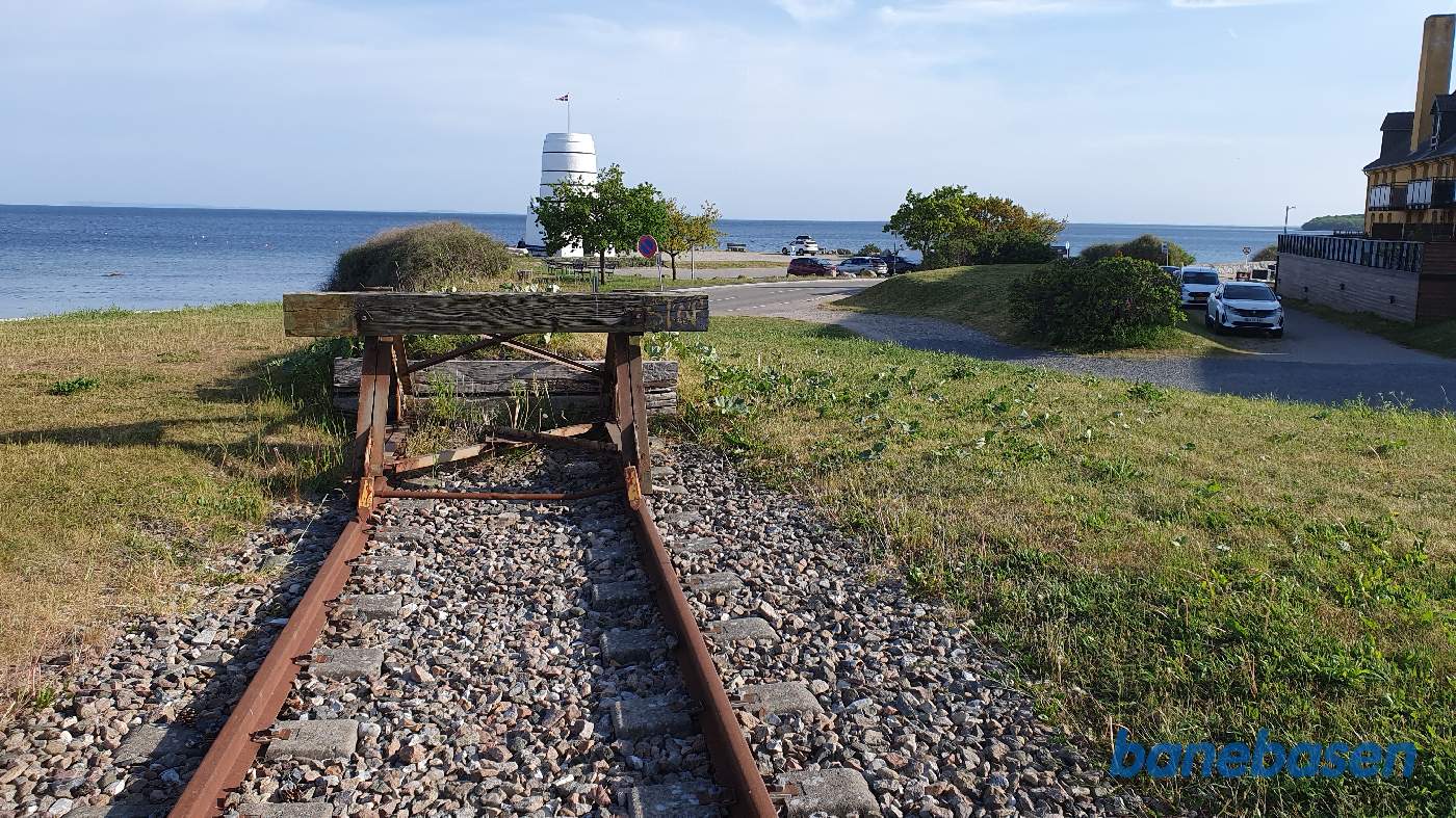 Her ved havet ender banen i en stopbom, havnesporet gik ned i højre side, hvor de to hvide biler holder