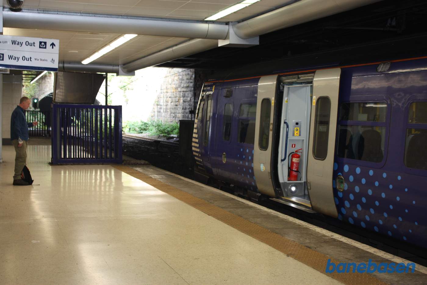Lokale tog kører fra en undergrundsstation nede under Queen Street station