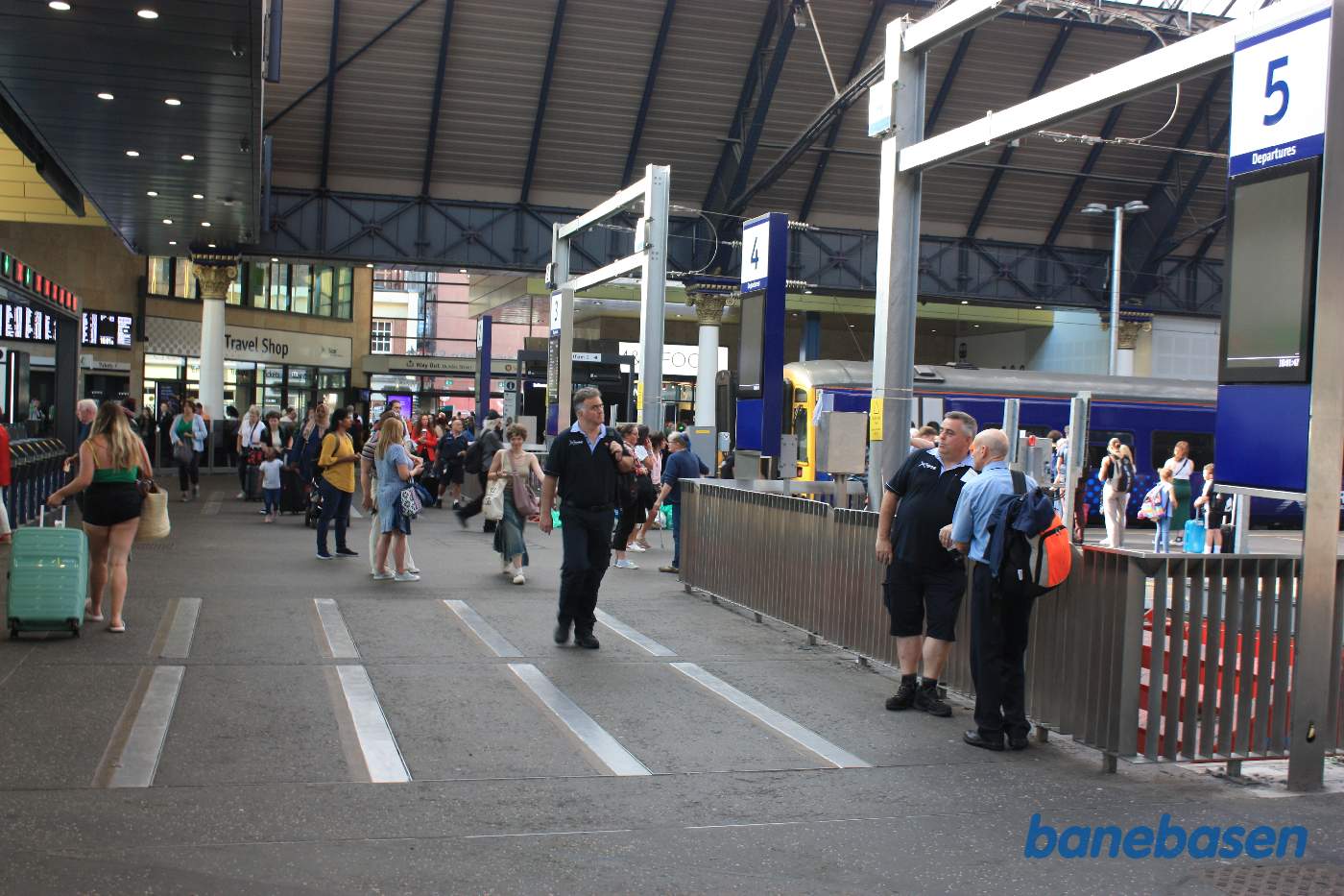 Et vue ud over området for enden af sporene med mange travle personer