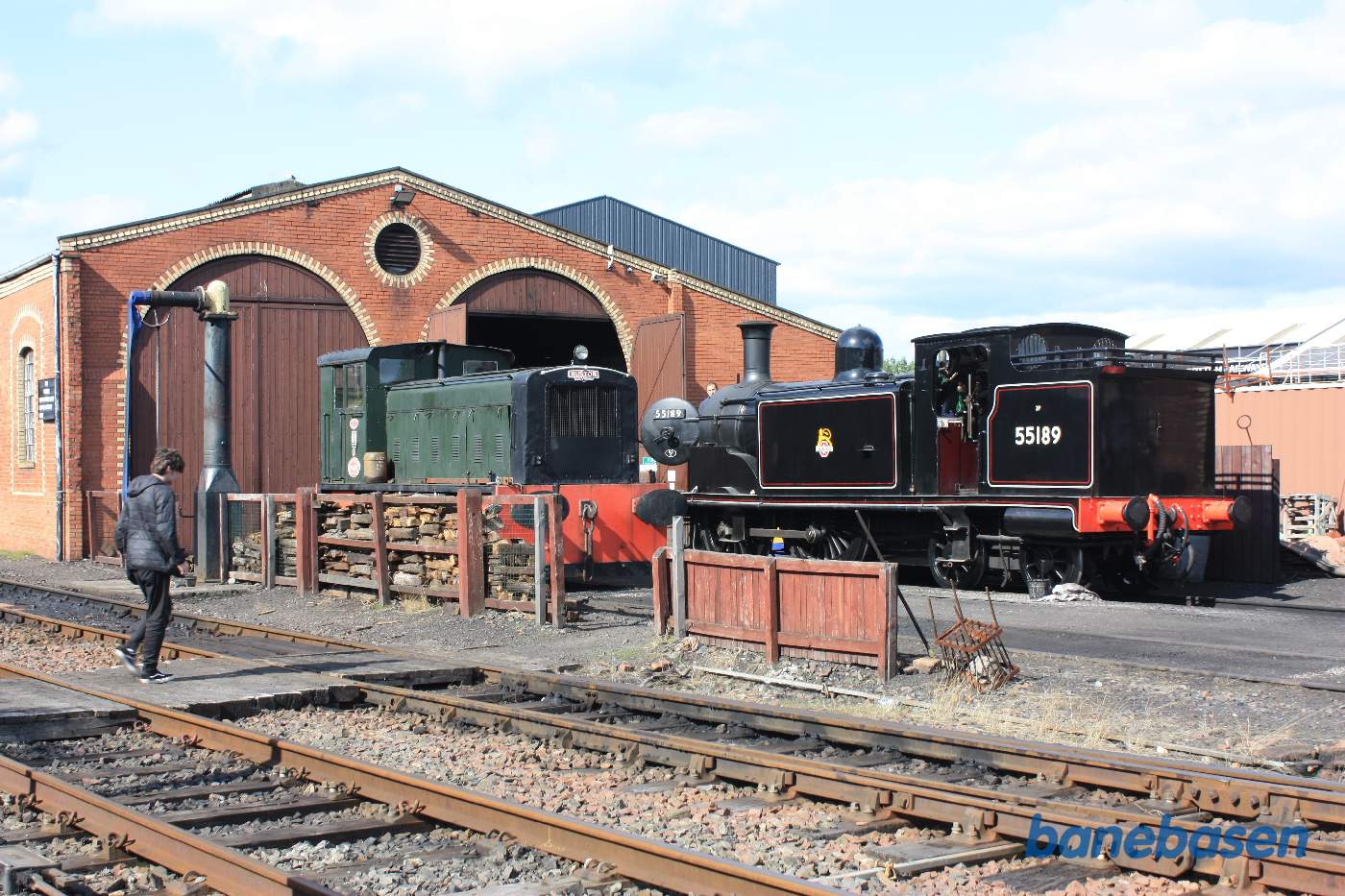 Et flot damplokomotiv står foran porten til remisen