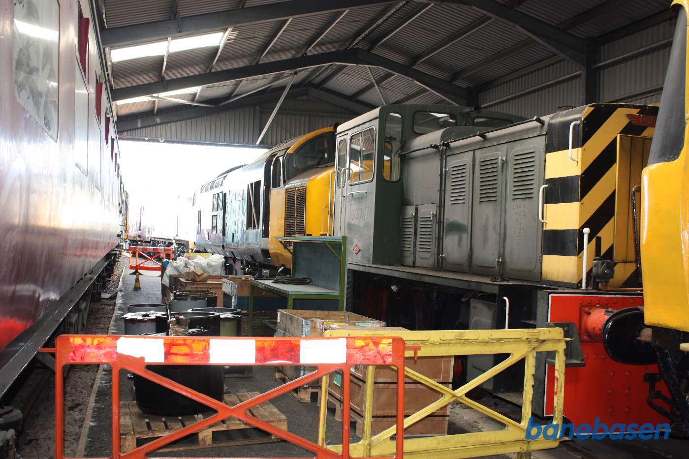 Inde i den store vognhal står lange rækker af rullende materiel, her et par diesellokomotiver