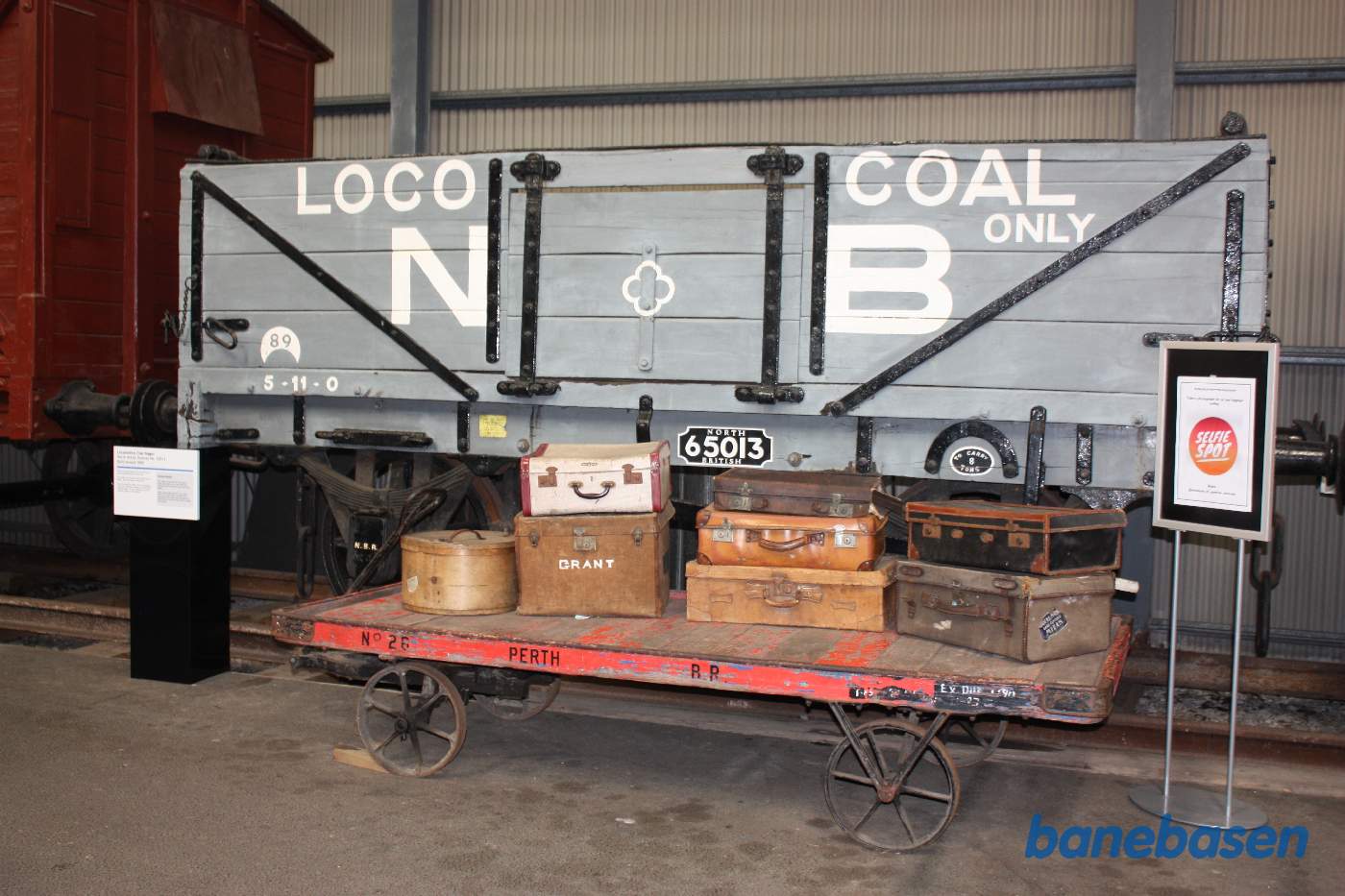 En vogn med kufferter foran en godsvogn