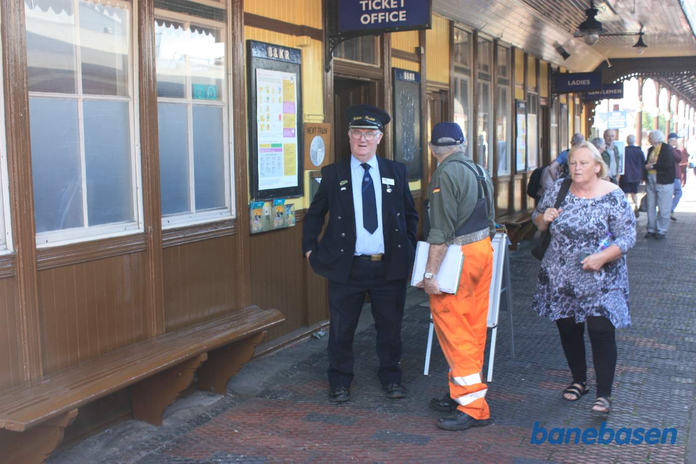 Stationsforstanderen, en frivillig og gæster udenfor billetkontoret
