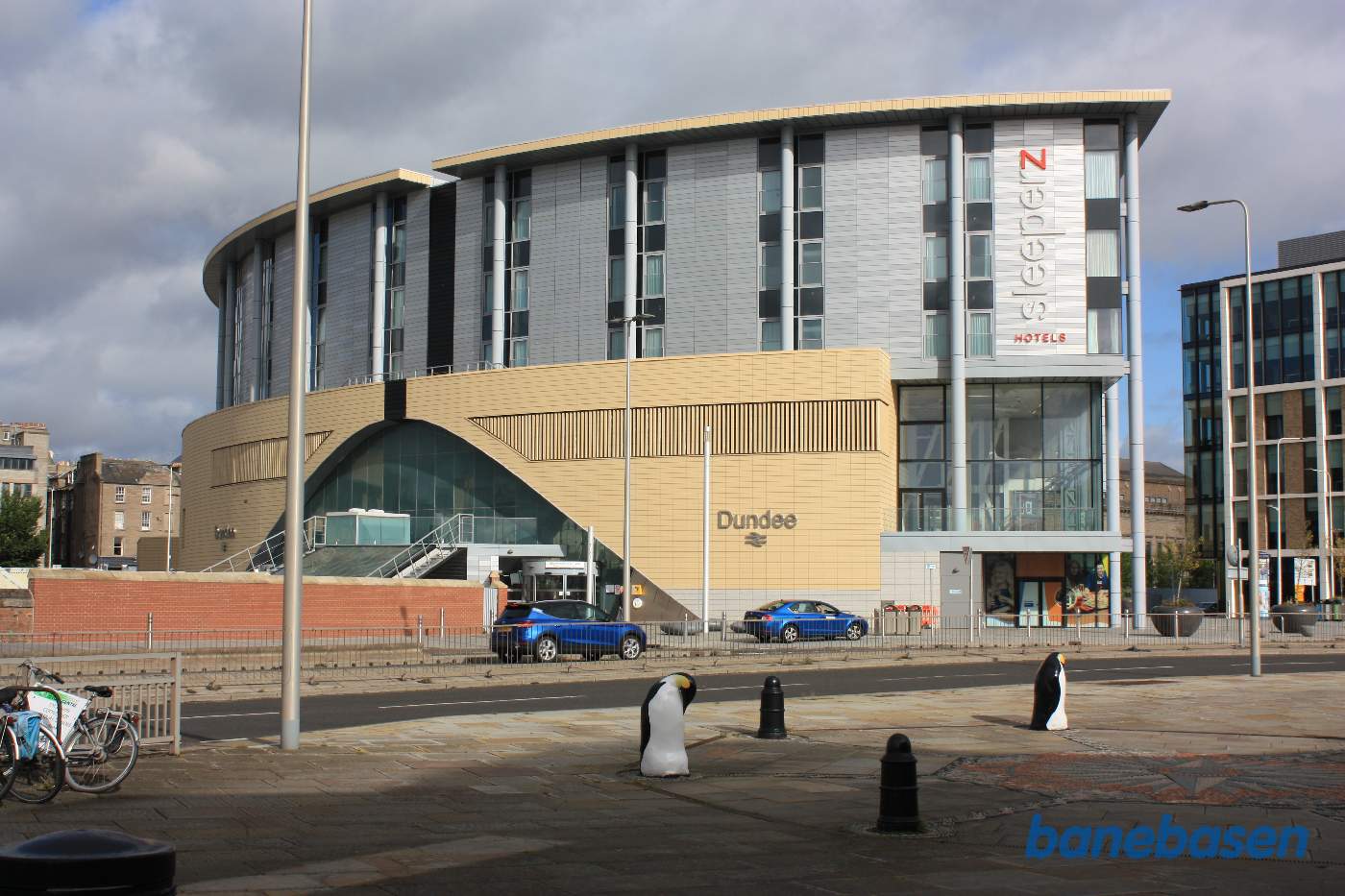 Stationsbygningen set oppe fra gaden, perroner og spor nede under gadeplan i tunnel