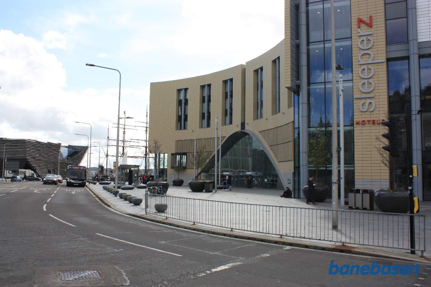 Hovedindgangen til stationsbygningen set oppe fra gaden, perroner og spor nede under gadeplan i tunnel