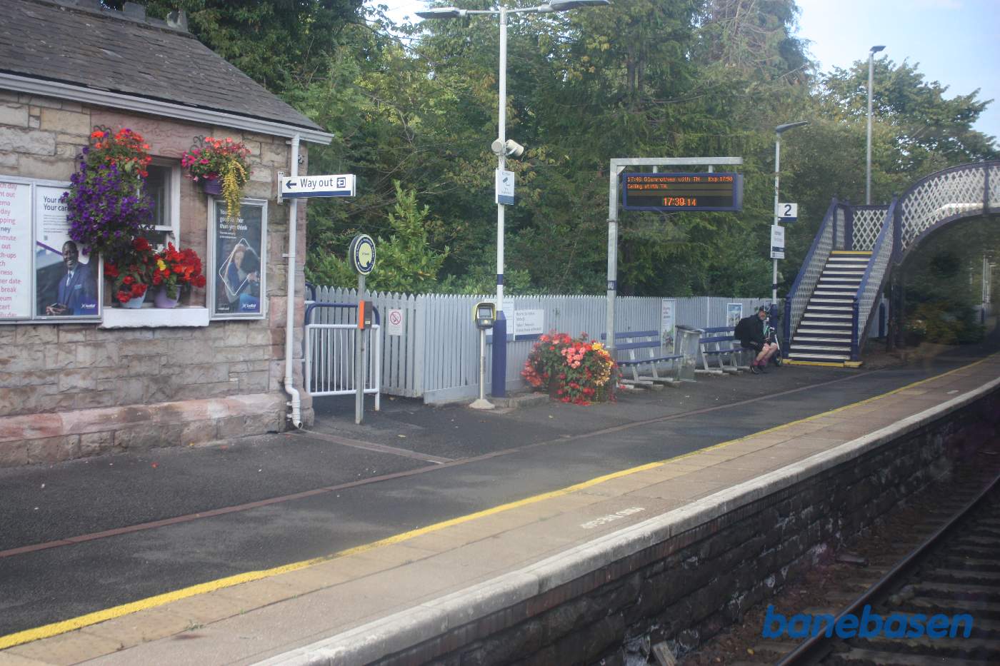 Et skud ud af togvinduet af perron og station, bemærk de flotte blomster krukker