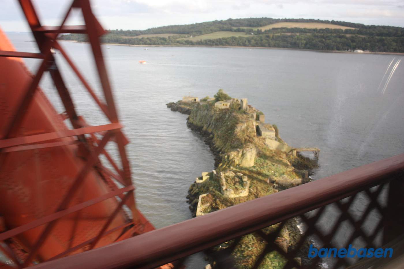 Et skud ud af togvinduet af den lille ø med Inch Garvie Castle og den kraftige brokonstruktion