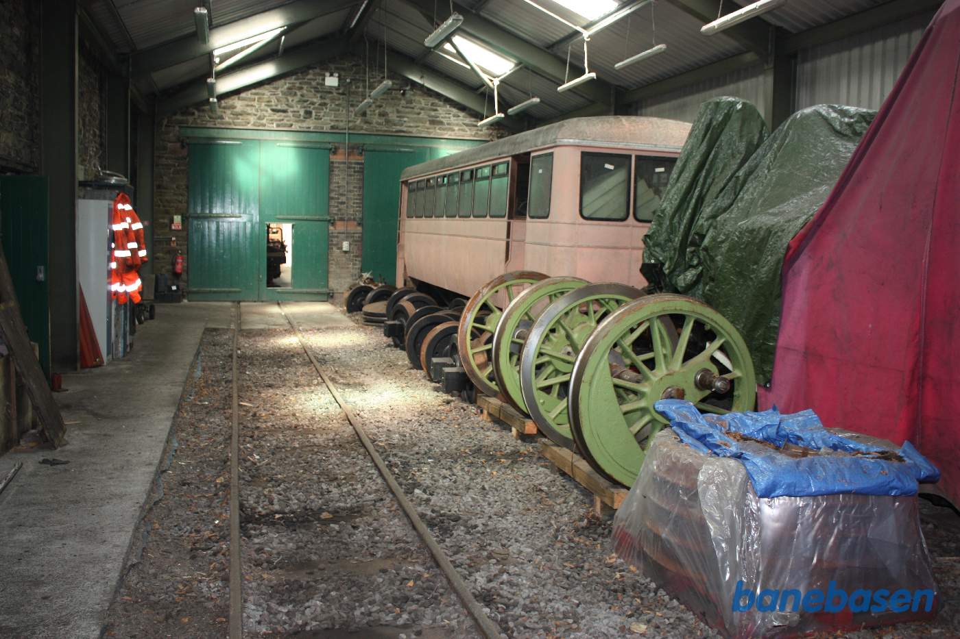 En lille mellemhal med en vognkasse og hjulaksler til et damplokomotiv